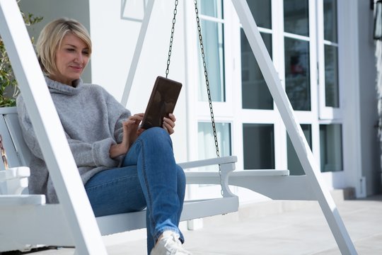 Beautiful woman using digital tablet in porch