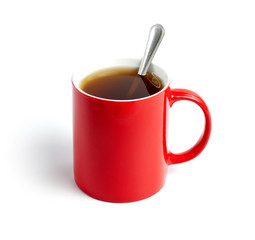 Red cup of tea with spoon on white background