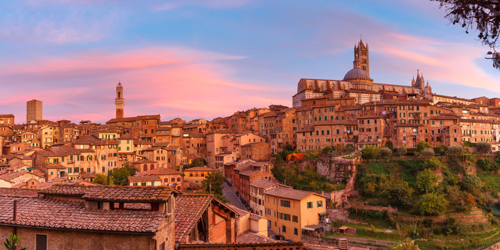 Beautiful panoramic view of Old Town with Dome and campanile of Siena Cathedral, Duomo di Siena, and Mangia Tower or Torre del Mangia at gorgeous sunset, Siena, Tuscany, Italy