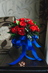 Golden wedding rings on the background of a wedding bouquet of red roses