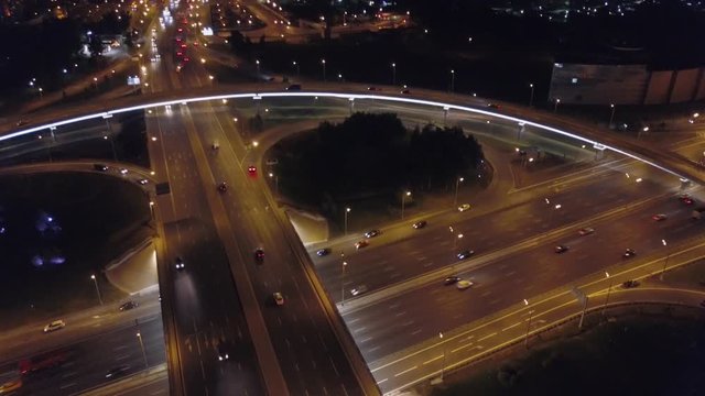 Aerial: Big road junction at Moscow beltway with automobiles and night city lights