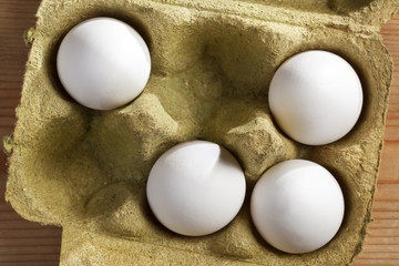 Four organic eggs in a box made of grass