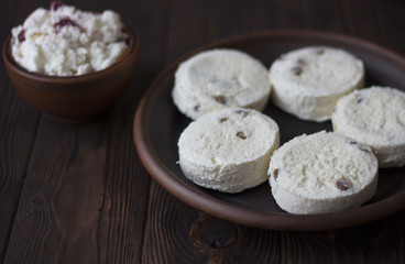 Russian traditional syrniki cottage cheese pancakes and jam breakfast in an earthenware bowl on a wooden table
