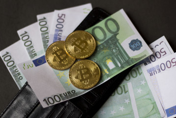 Golden bitcoins and banknotes Euro in my wallet on a black background. the new virtual money
