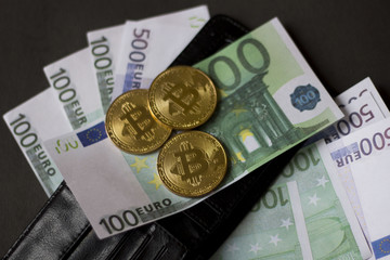 Golden bitcoins and banknotes Euro in my wallet on a black background. the new virtual money