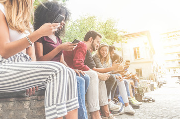 Diverse culture friends using smartphones outdoor - Group of happy people having fun with technology trends - Youth, new generation addiction and friendship concept - Main focus on left bearded man