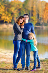 happy family resting outdoors, amicably hugging and smiling