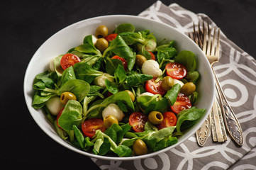 Salad with tomatoes, mozarella and olives.