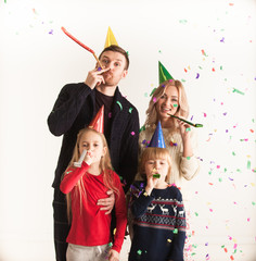 Family blowing party trumpets with confetti