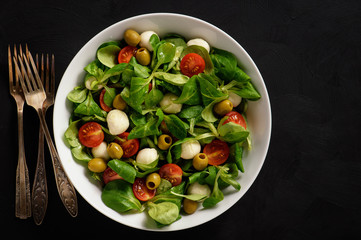 Salad with tomatoes, mozarella and olives.