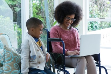 Son and his disabled mother using laptop