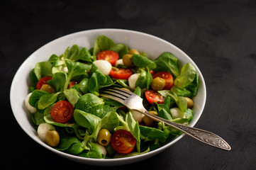 Salad with tomatoes, mozarella and olives.
