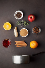 Culinary background with ingredients for recipe of mulled wine on dark brown table.