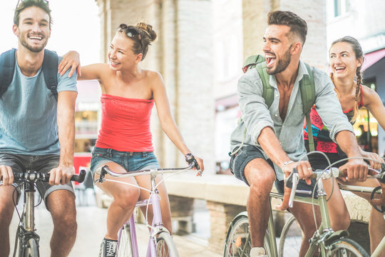 Happy Best Friends Riding Bicycles In City Center