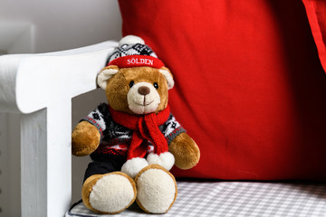 Teddy bear in a chair under the Christmas tree