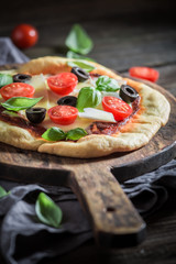 Homemade pizza with tomatoes, basil and cheese