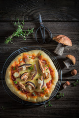 Yummy rustic pizza with noble mushrooms and thyme