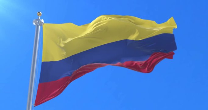 Colombia flag waving at wind in slow with blue sky, loop