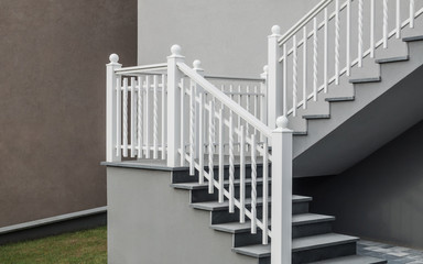 Moderne freitragende Treppe mit Granitauflage und Treppengeländer aus weiß lackiertem Aluminium -...