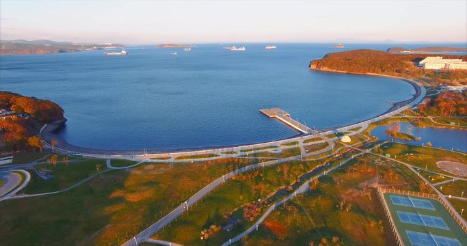 Panoramic view of modern university in the Russian Far East. Russian Far Eastern Federal University campus and bay with pier, Russky Bridge of Vladivostok on background. Aerial view.