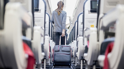 Obraz premium Pasażer w samolocie z walizką
