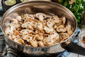Mushrooms and onion on a fried pan