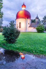 Heuwinklkapelle in Iffeldorf nach dem Regen spiegelt sich in einer Pfütze