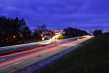 Night photo traffic on the road. Evening landscape with cars. Cars with lights and blurred color lines.