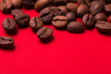 Roasted coffee beans on red background. Color surge trend.