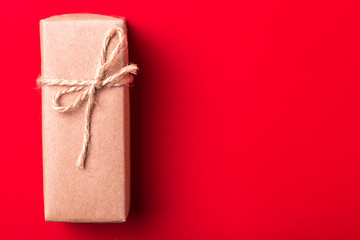 Gift box on red background. Flat lay. Color surge.