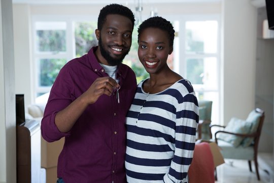 Happy couple holding a key of new house