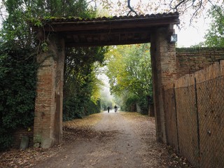 Naklejka premium Country road with large brick portal.