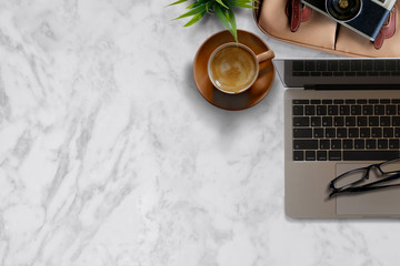 Mock up Desk work vintage camera, laptop, notebook and plant on marble table background. Top view and copy space.