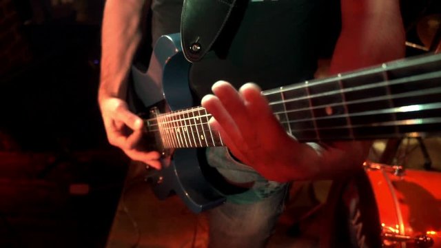 Rock musician plays solo on electric guitar. Playing hands on rock guitarist