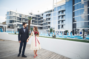Elegant beautiful couple posing near modern glass building