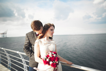 Married wedding couple standing on a wharf over the sea