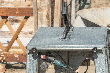 Construction site with work materials such as wheelbarrow, table saw