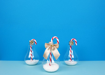 Striped christmas candy canes on blue background.