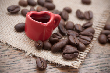 grains de café et tasse en forme de coeur sur table en bois