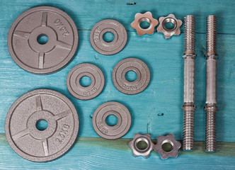 Top view of accessories for fitness in grey tone. Dumbbells, weight plates.