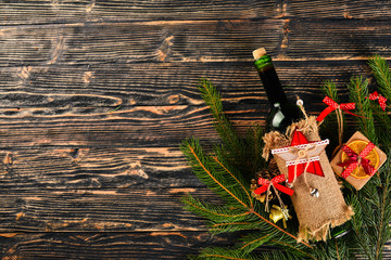 Christmas table serving, and a bottle of wine. New Year. Christmas tree and Christmas tree decorations. On a wooden background. Free space for text.
