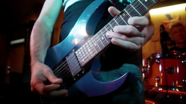 Rock musician plays solo on electric guitar. Playing hands on rock guitarist