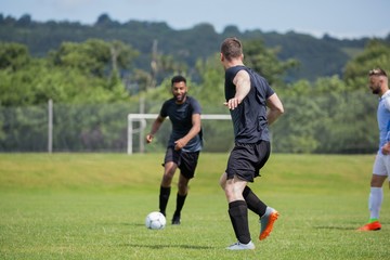 Football players playing soccer in the ground