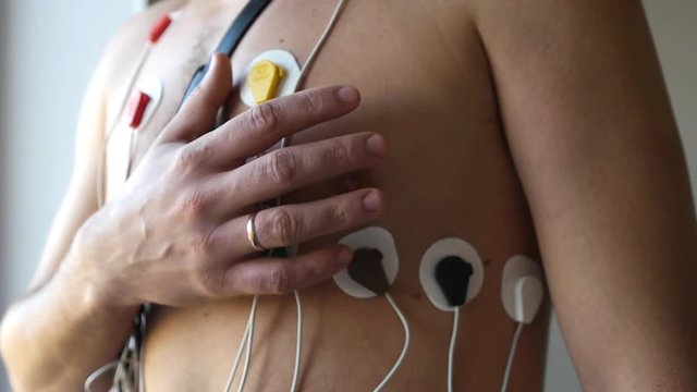 11.4.2017 Novosibirsk, Russia.. A man takes his hand in the heart while standing in the sensors of the holter. HD, 1920x1080, slow motion