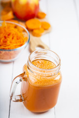 Apple-carrot juice on a wooden table.