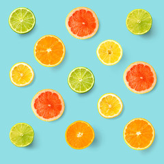 Creative layout made of lemon, lime, orange and grapefruit. Flat lay. Food concept. Lemon, lime, orange and grapefruit on turquoise background.