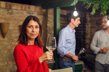 Party time in backyard. Woman holding glass of wine