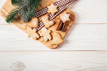Gingerbread on the wooden breadboard,fir,cinnamon,ribbon.Christmas,holiday and new year concept.Top view.Flat lay.