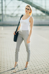 Business woman standing on the street at sunset