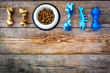 Concept pet care, playing and training. Toys, accessories and feed on wooden background top view copyspace
